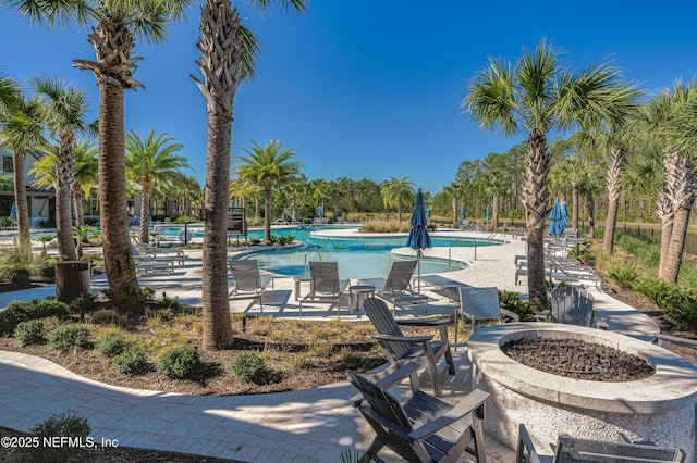 view of swimming pool featuring a patio and an outdoor fire pit