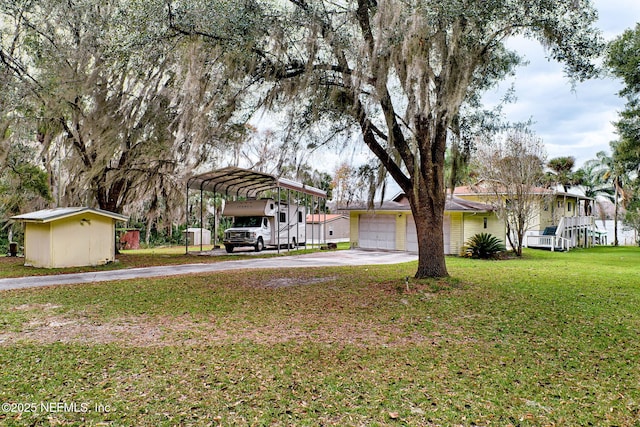 view of front facade with a carport, a garage, a shed, and a front yard