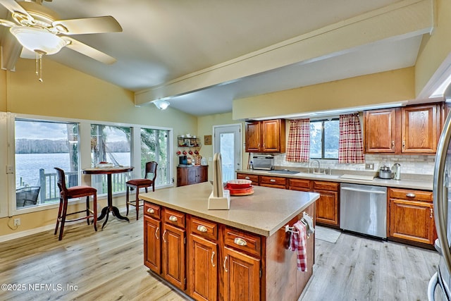 kitchen with decorative backsplash, vaulted ceiling with beams, dishwasher, a center island, and light hardwood / wood-style floors