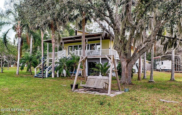 back of property featuring covered porch and a yard