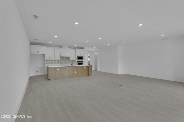 kitchen featuring visible vents, backsplash, open floor plan, recessed lighting, and light countertops