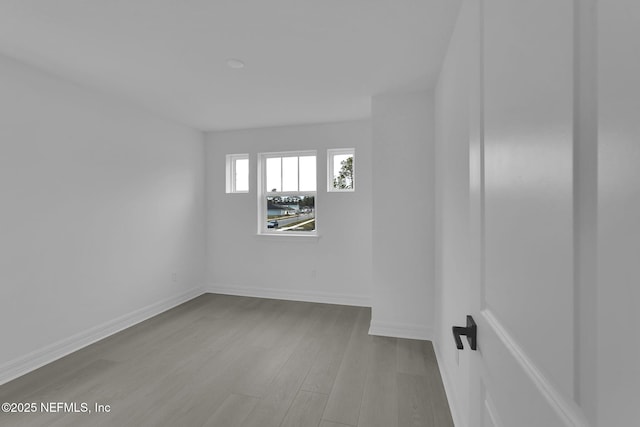 empty room with baseboards and wood finished floors