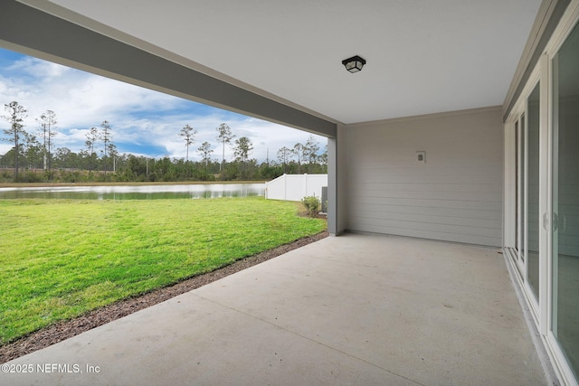 view of patio with fence and a water view