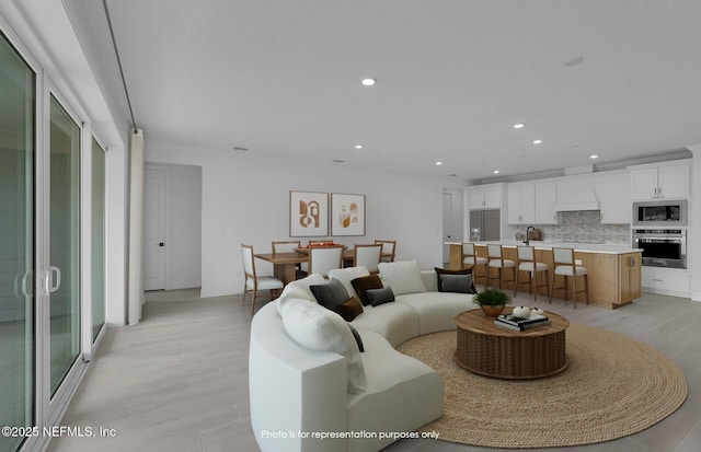 living area featuring light wood-style flooring and recessed lighting