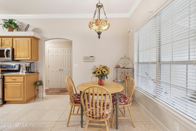 tiled dining room featuring ornamental molding and plenty of natural light