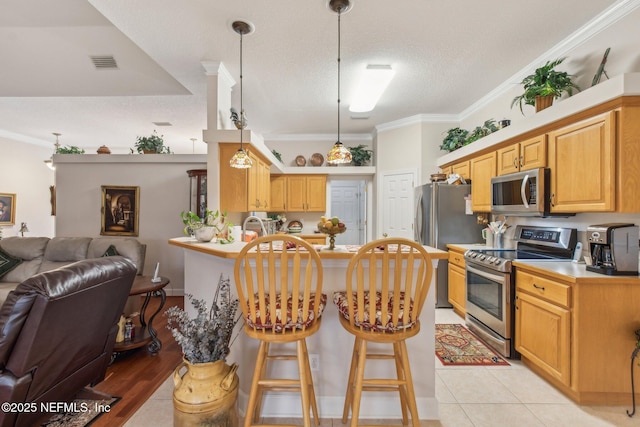 kitchen with stainless steel appliances, hanging light fixtures, crown molding, and kitchen peninsula