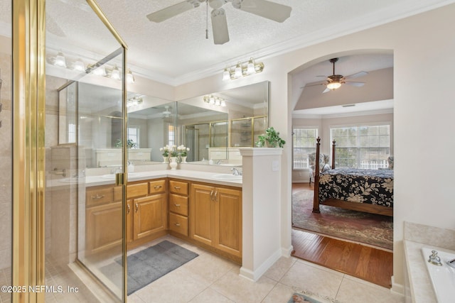 bathroom featuring shower with separate bathtub, a textured ceiling, tile patterned flooring, vanity, and crown molding