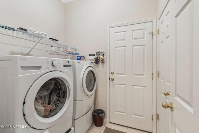 clothes washing area with washing machine and clothes dryer and light tile patterned floors