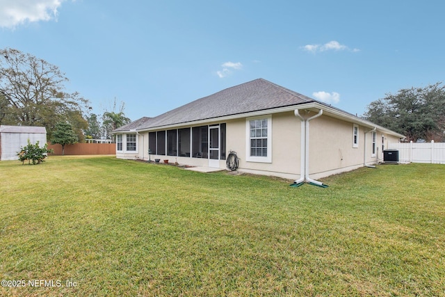 back of house with a yard, central air condition unit, and a sunroom