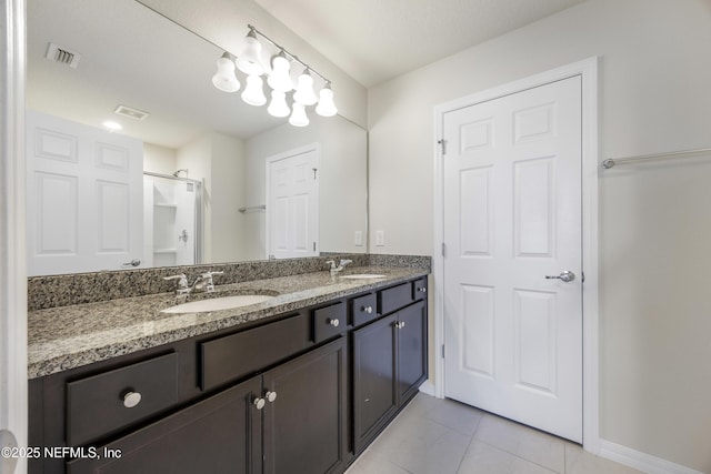 bathroom featuring tile patterned flooring, vanity, and walk in shower