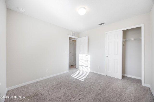 unfurnished bedroom with light colored carpet and a closet