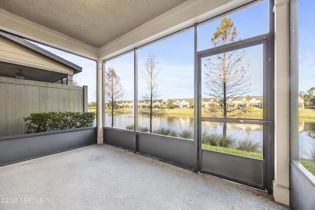 unfurnished sunroom featuring a water view