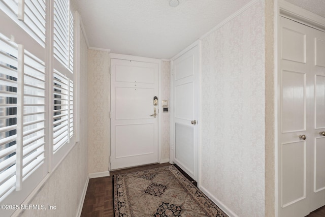 doorway to outside with a textured ceiling and dark parquet floors