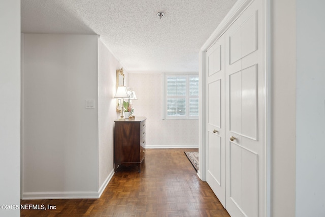 hallway with a textured ceiling and dark parquet floors