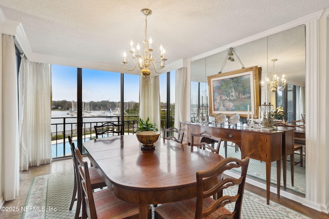 dining room with light wood-type flooring, a textured ceiling, an inviting chandelier, and ornamental molding