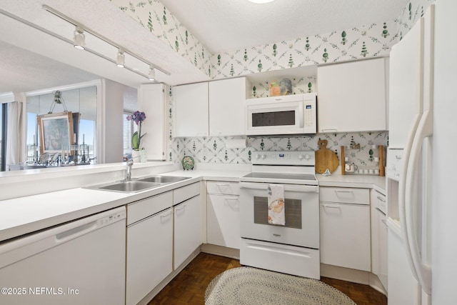 kitchen with dark hardwood / wood-style flooring, white appliances, white cabinetry, and sink