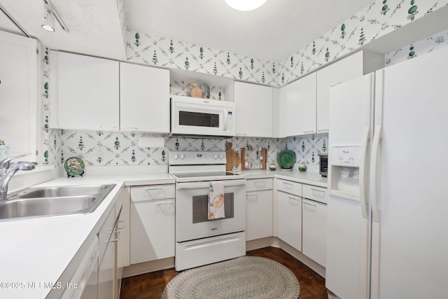 kitchen featuring white cabinets, white appliances, and sink