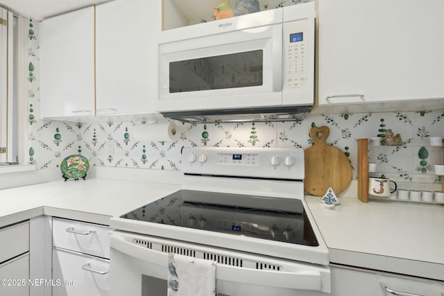 kitchen with white cabinets, white appliances, and tasteful backsplash