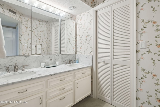 bathroom with a textured ceiling and vanity