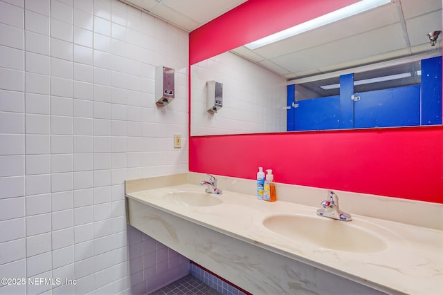 bathroom with sink and tile walls