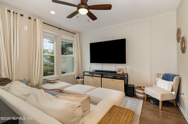 living room with ceiling fan, a textured ceiling, and hardwood / wood-style floors