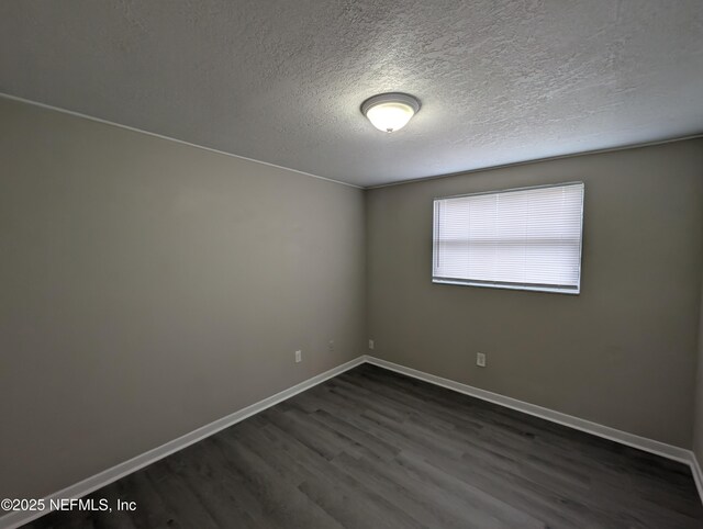 unfurnished room featuring dark hardwood / wood-style floors and a textured ceiling