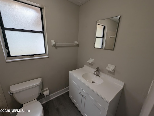 bathroom with hardwood / wood-style floors, vanity, and toilet