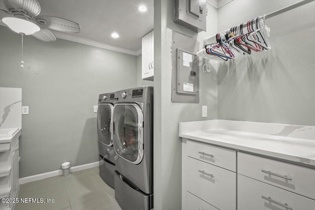 laundry area featuring washer and clothes dryer, cabinets, electric panel, crown molding, and ceiling fan