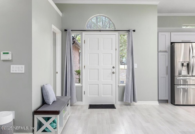 foyer entrance with light wood-type flooring, plenty of natural light, and crown molding