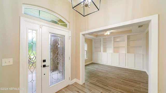 foyer with a wealth of natural light and a notable chandelier