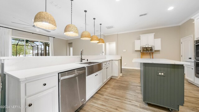 kitchen with stainless steel appliances, white cabinetry, hanging light fixtures, and a large island