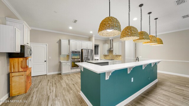 kitchen featuring a kitchen bar, appliances with stainless steel finishes, backsplash, pendant lighting, and white cabinets