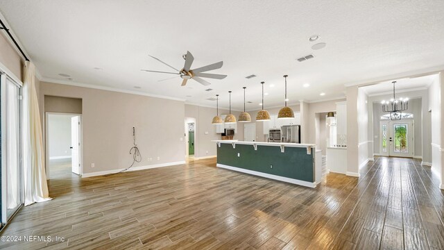 kitchen featuring decorative light fixtures, stainless steel fridge, and ornamental molding