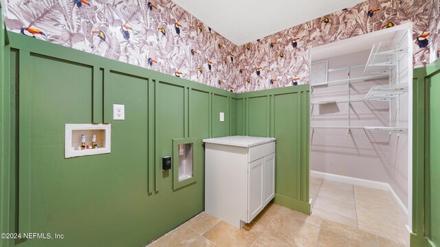 laundry room with cabinets, hookup for a washing machine, and light tile patterned floors