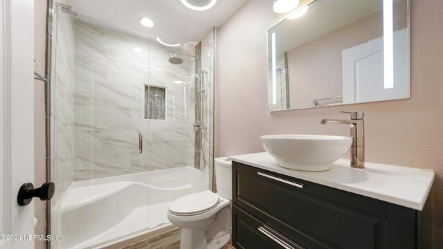 bathroom featuring hardwood / wood-style flooring, vanity, toilet, and a shower with door