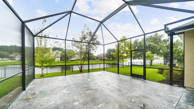 unfurnished sunroom featuring a water view