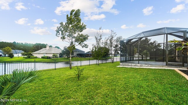 view of yard with a lanai and a water view