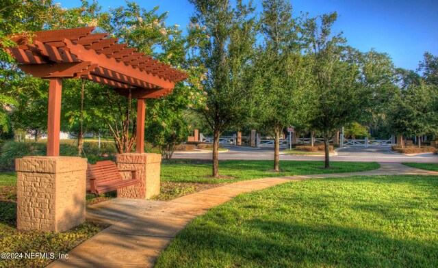 surrounding community with a pergola and a yard