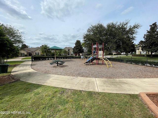 community playground featuring a lawn and fence