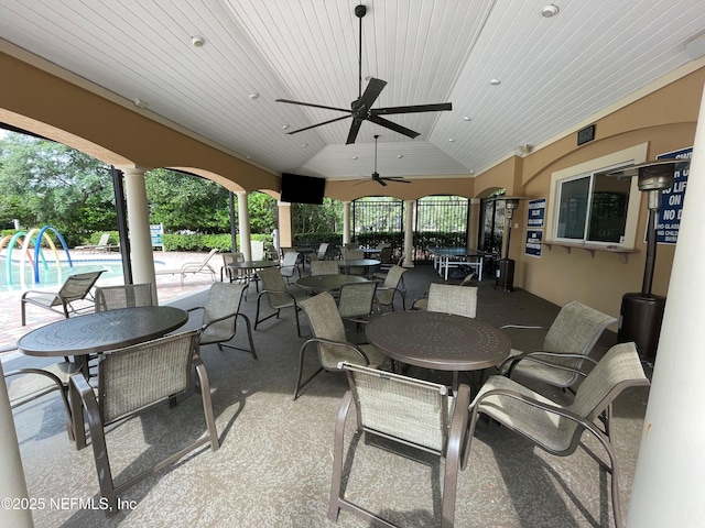 view of patio / terrace with outdoor dining area, ceiling fan, and a community pool