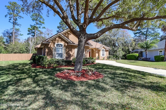 ranch-style house featuring stucco siding, fence, concrete driveway, and a front yard