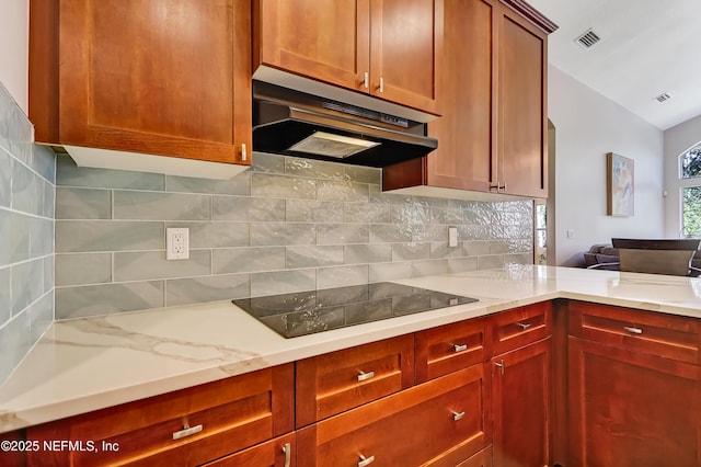 kitchen with under cabinet range hood, tasteful backsplash, visible vents, and black electric stovetop