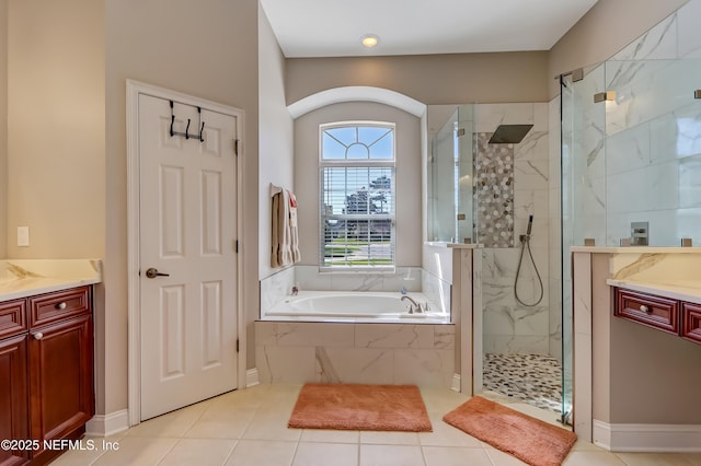 bathroom featuring tile patterned floors, a marble finish shower, a bath, and vanity