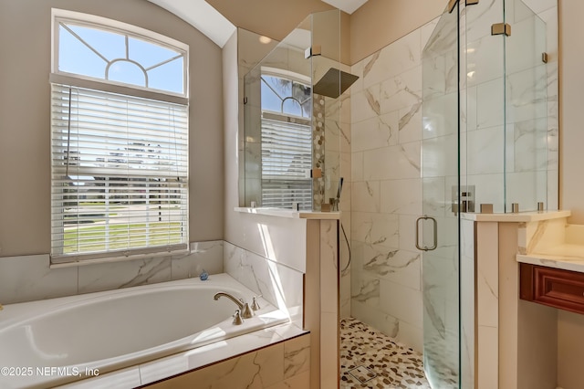 bathroom with a stall shower and a garden tub