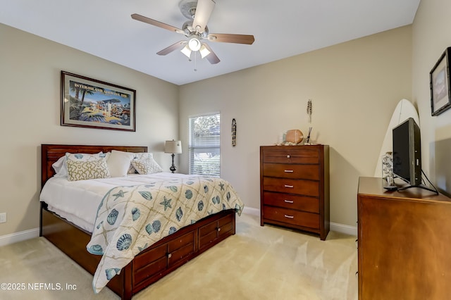 bedroom featuring light carpet, a ceiling fan, and baseboards