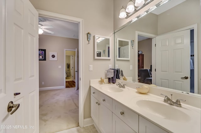 full bathroom with double vanity, ceiling fan, connected bathroom, and a sink