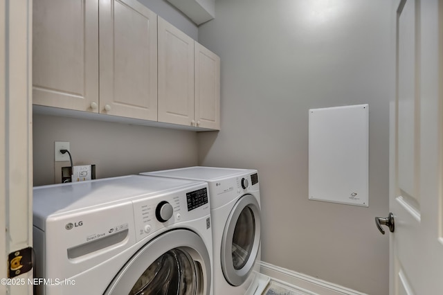 laundry room featuring independent washer and dryer, cabinet space, and baseboards