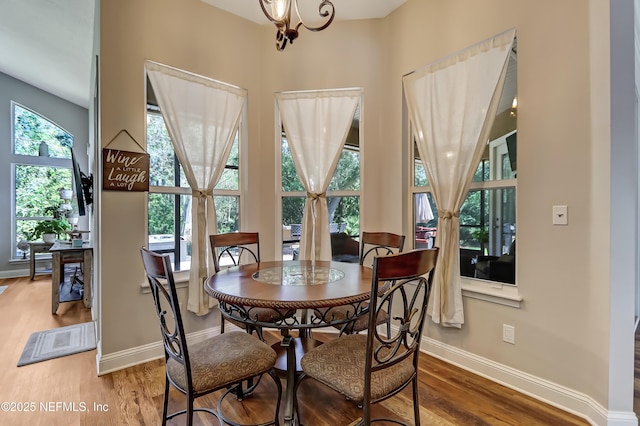 dining area with an inviting chandelier, wood finished floors, and baseboards