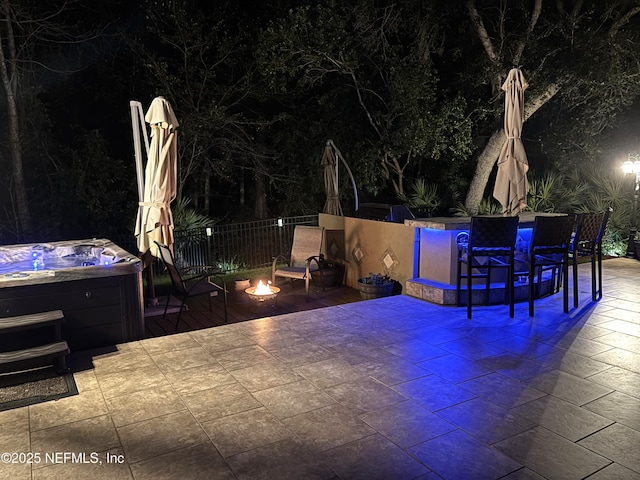 view of patio with a fire pit and a hot tub