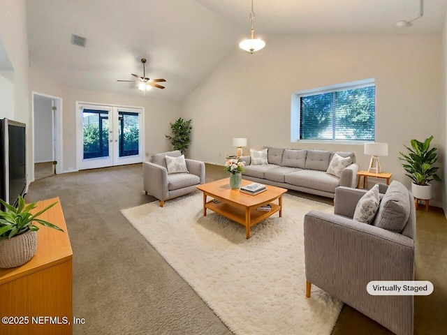 living room with ceiling fan, a healthy amount of sunlight, and vaulted ceiling